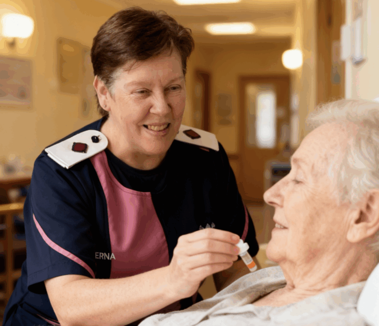 Nurse Gerna gently administering pain medication to an elderly resident at Summervale Care Centre, demonstrating compassion and attentive care during chronic pain management.”